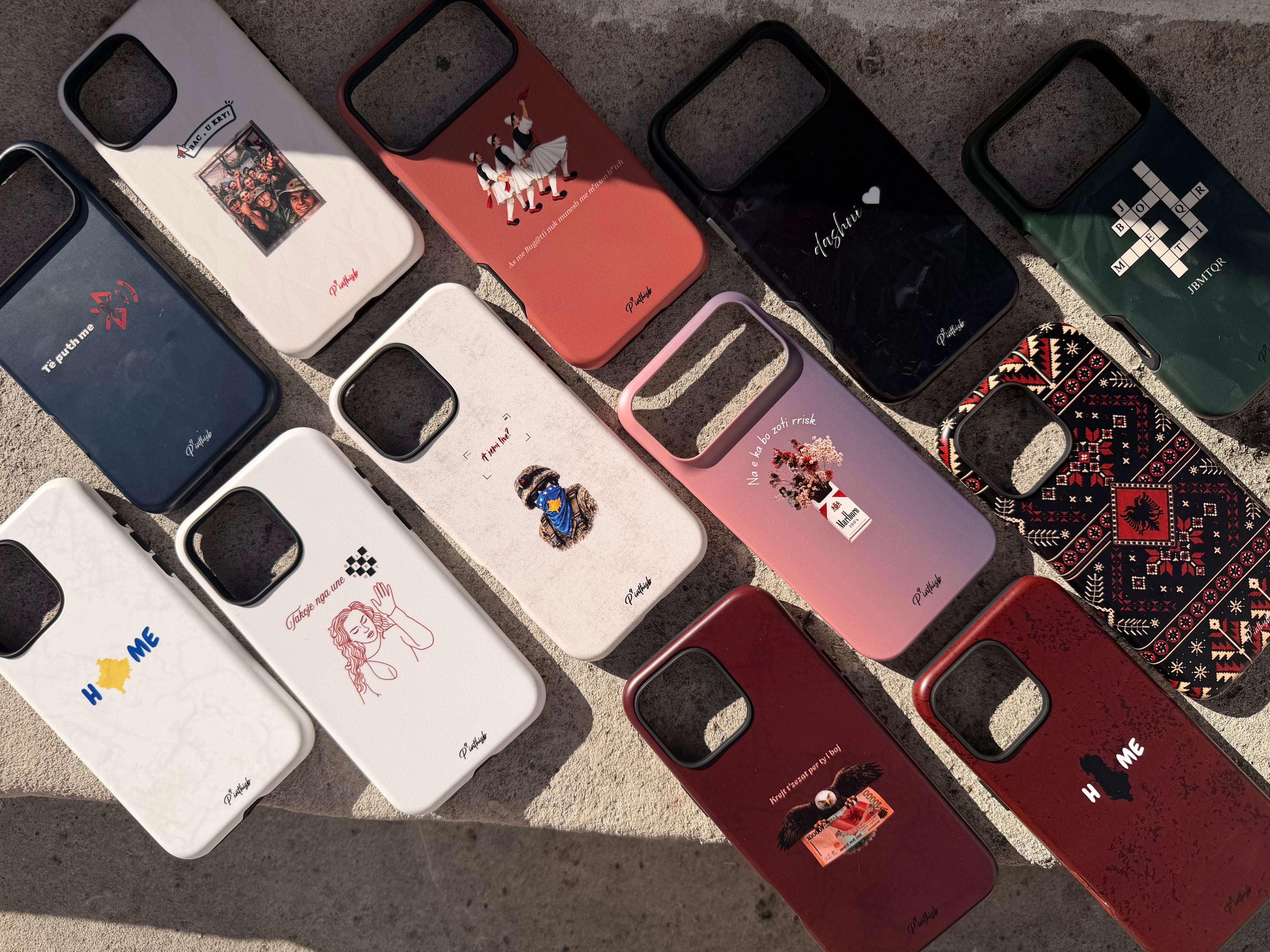 Collection of various phone cases with different designs on a textured surface