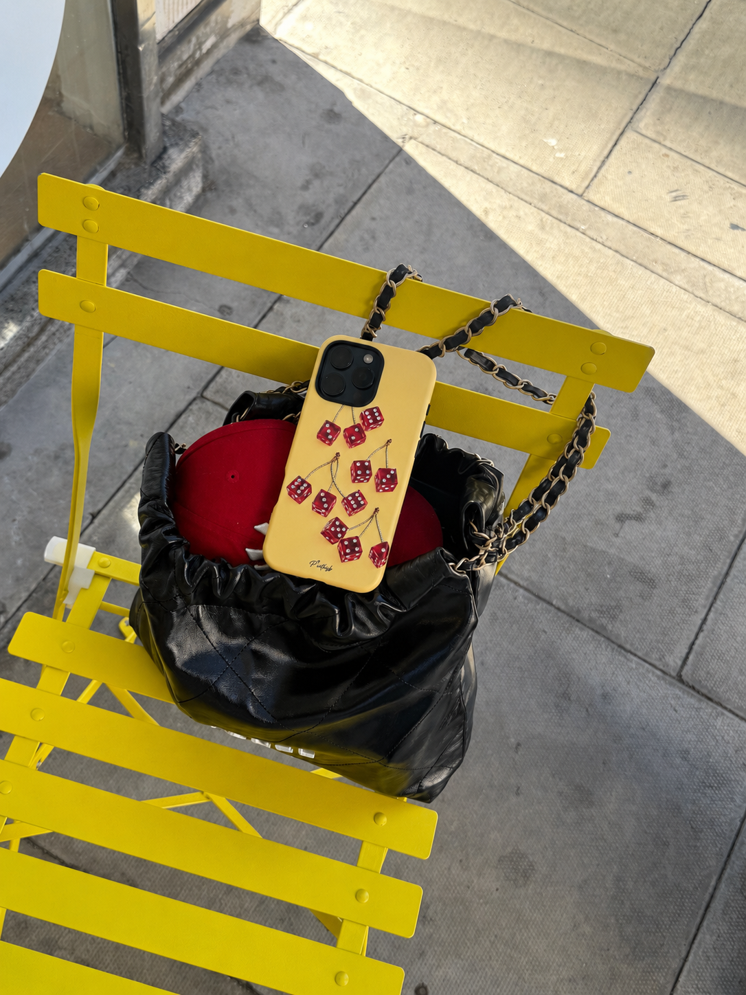 yellow red cherry dice phone case on a nice black bag